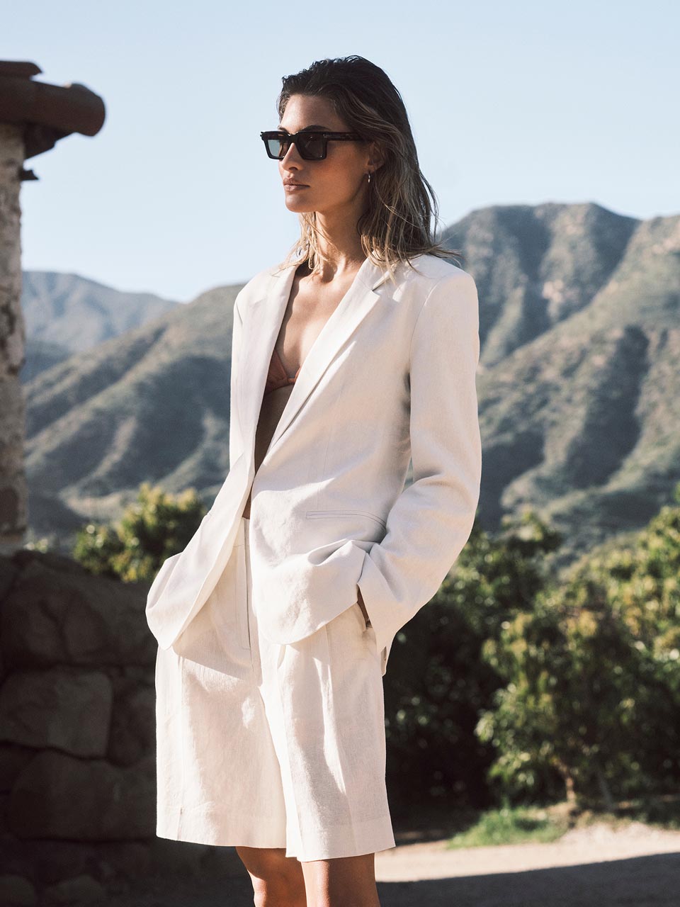Model posing in tailored white shorts 
